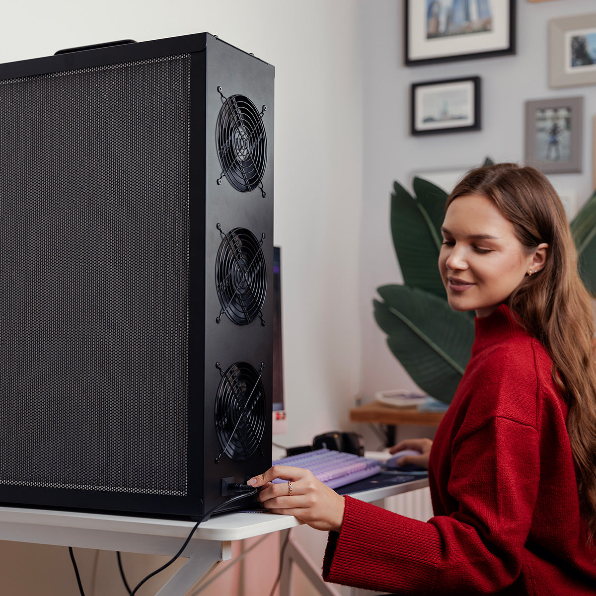 Woman in a red sweater adjusting the speed on her Tempest Pro air purifier.